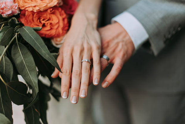 Image of a bride and groom hands with their wedding rings 