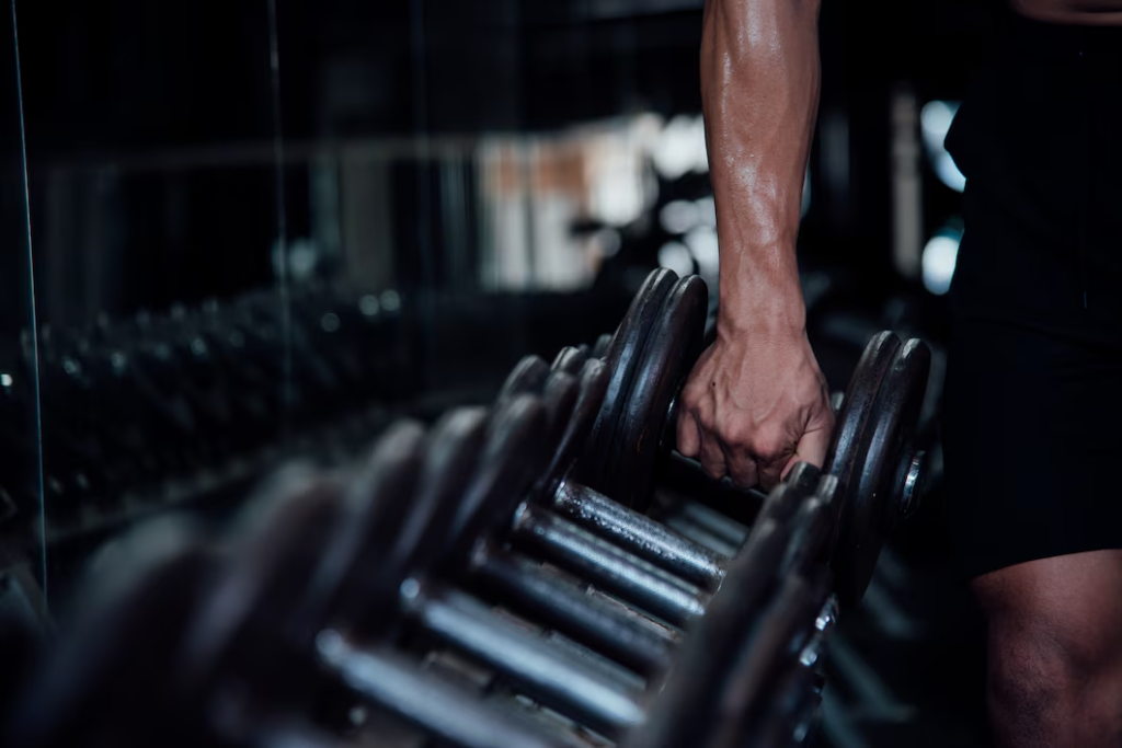 Shot of a man's hand picking up a dumbbell