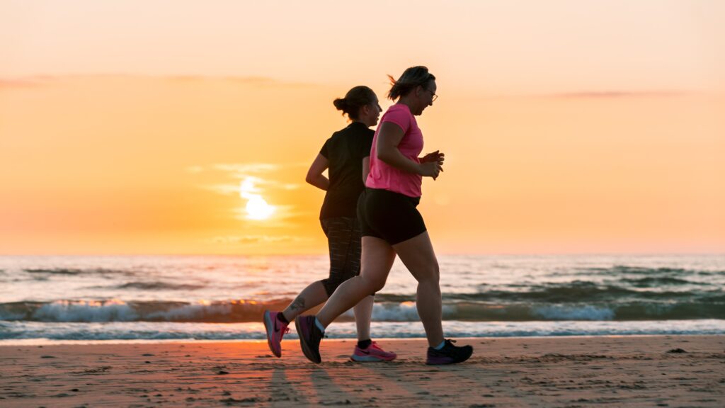 two girls jogging on the beach 