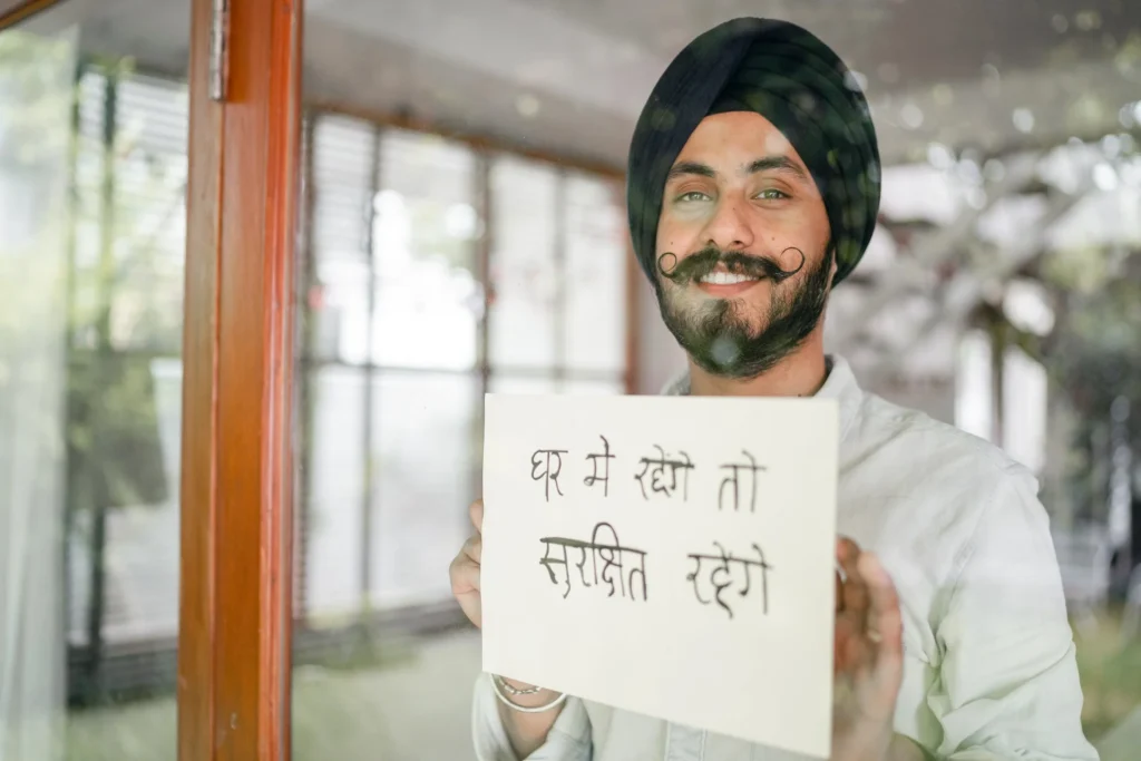 A guy holding a paper with Hindi inscription.