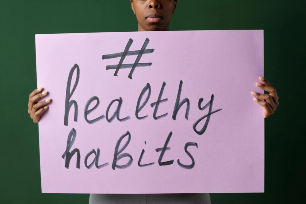 Person Holding Purple Slogan Poster with Motivational Hashtag #healthyhabits