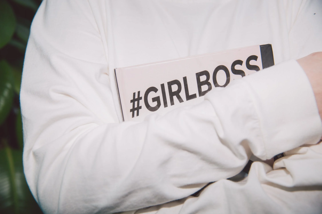 Woman Holding Book Titled With Motivational Hashtag #GIRLBOSS