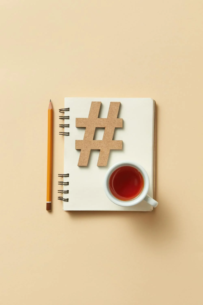 Ceramic Teacup on Top of a Notebook With a Hashtag on It and a Pencil Beside It