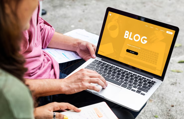 A man and woman working on a blog with a laptop in their lap