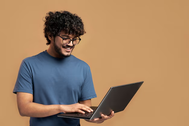 A happy boy is working on the laptop