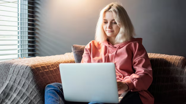 A girl is working by sitting on her sofa cozily